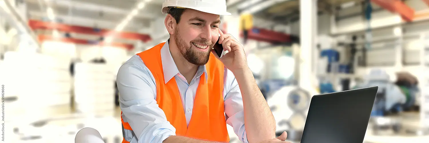 Mann mit Warnweste und Helm telefoniert am Mobiltelefon BILD: Link auf Leistungen